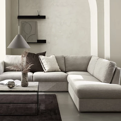 Grå chaiselongsoffa i minimalistiskt vardagsrum