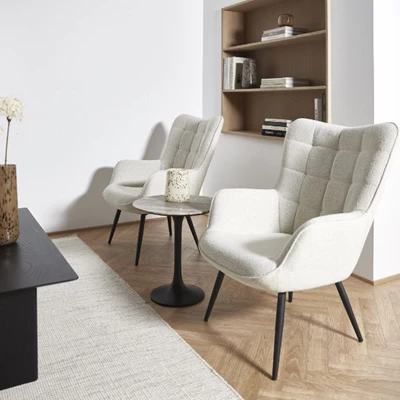 2 vita fåtöljer stående på trägolv framför en vit matta med en inbyggd hylla bakom på väggen