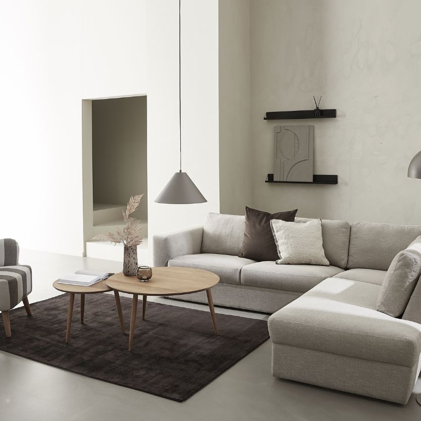 2 soffbord i trä i olika storlekar, satta ihop som sidobord på mörk matta. Bordarna står vid en grå hörnsoffa i en vardagsrumsinredning