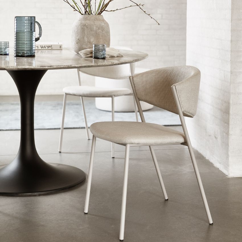 Runt matbord med stoppade stolar och dekoration