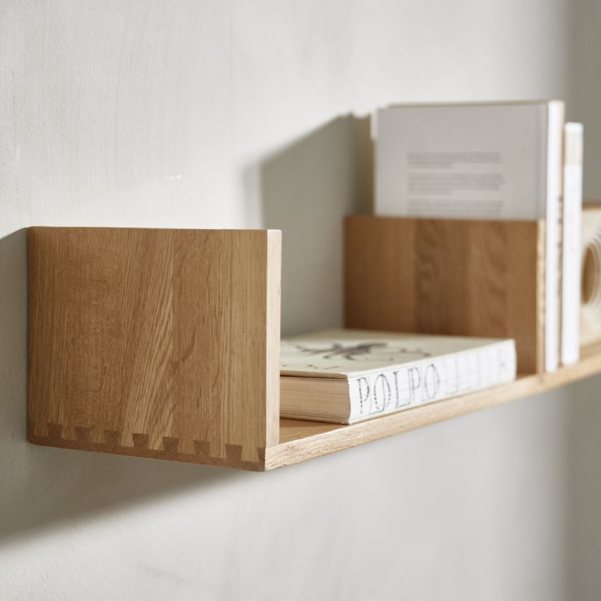 Vägghylla i trä med böcker i minimalistisk design