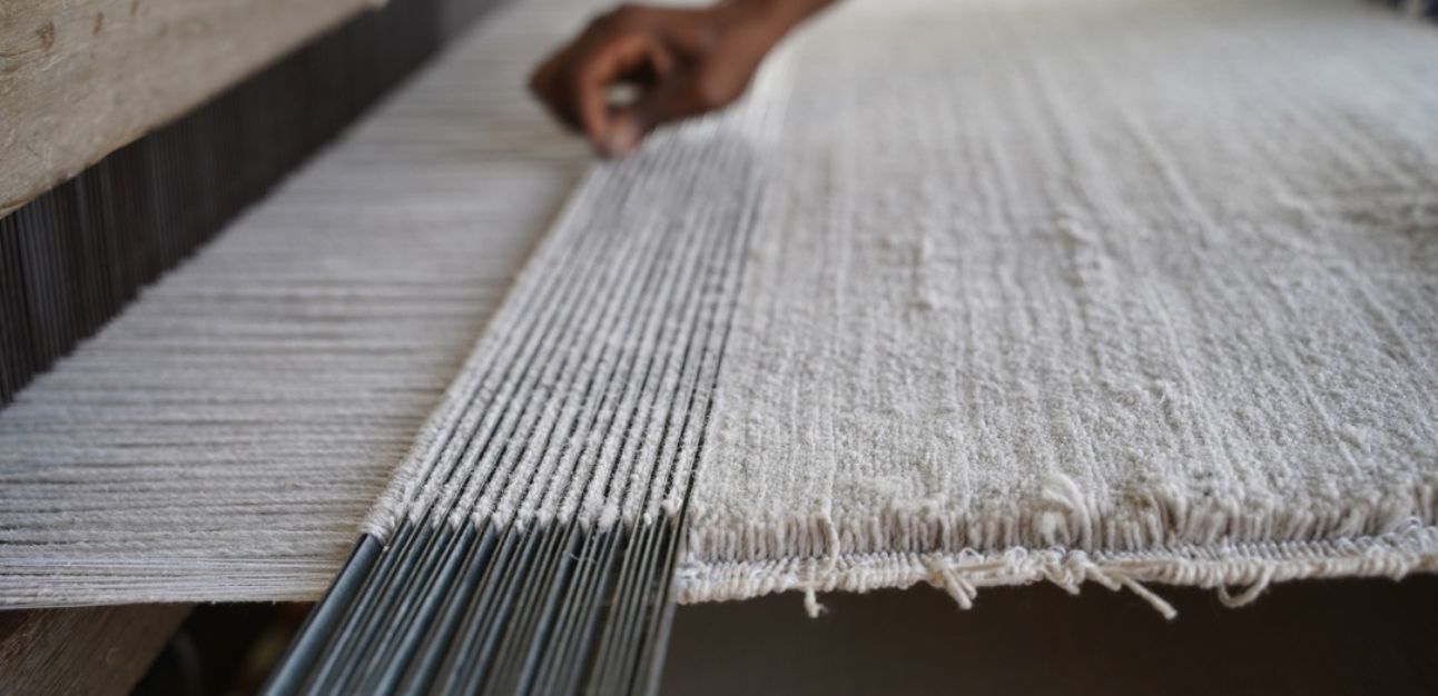 Handvävning av ljus matta på traditionell vävstol