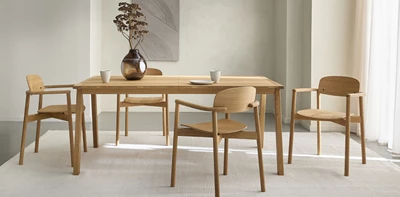 Matbord och matbordsstolar i trä på en ljus matta.