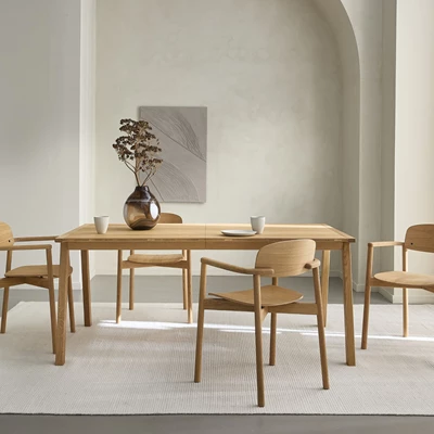 Matbord och matbordsstolar i trä på en ljus matta.