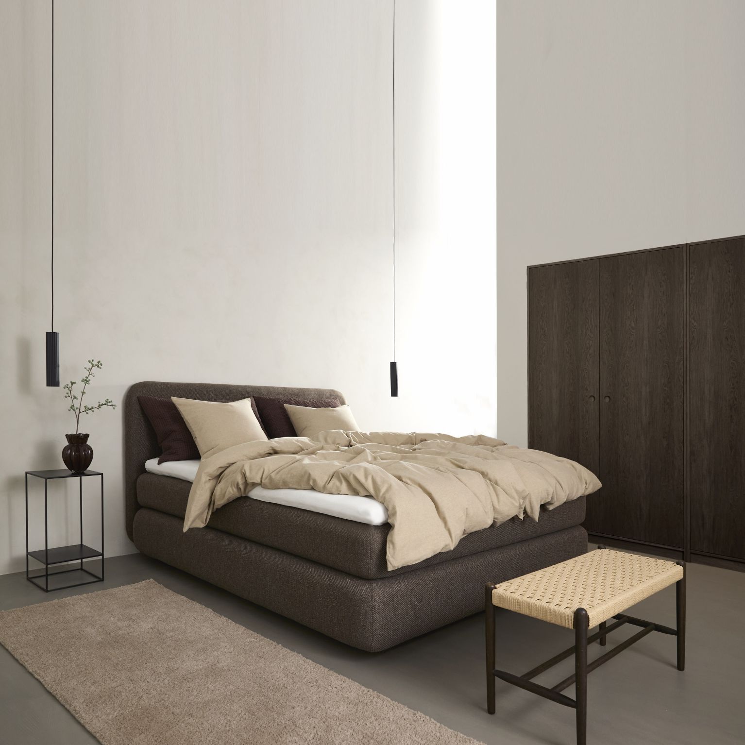 Sovrum i bruna nyanser med en kontinentalsäng i centrum