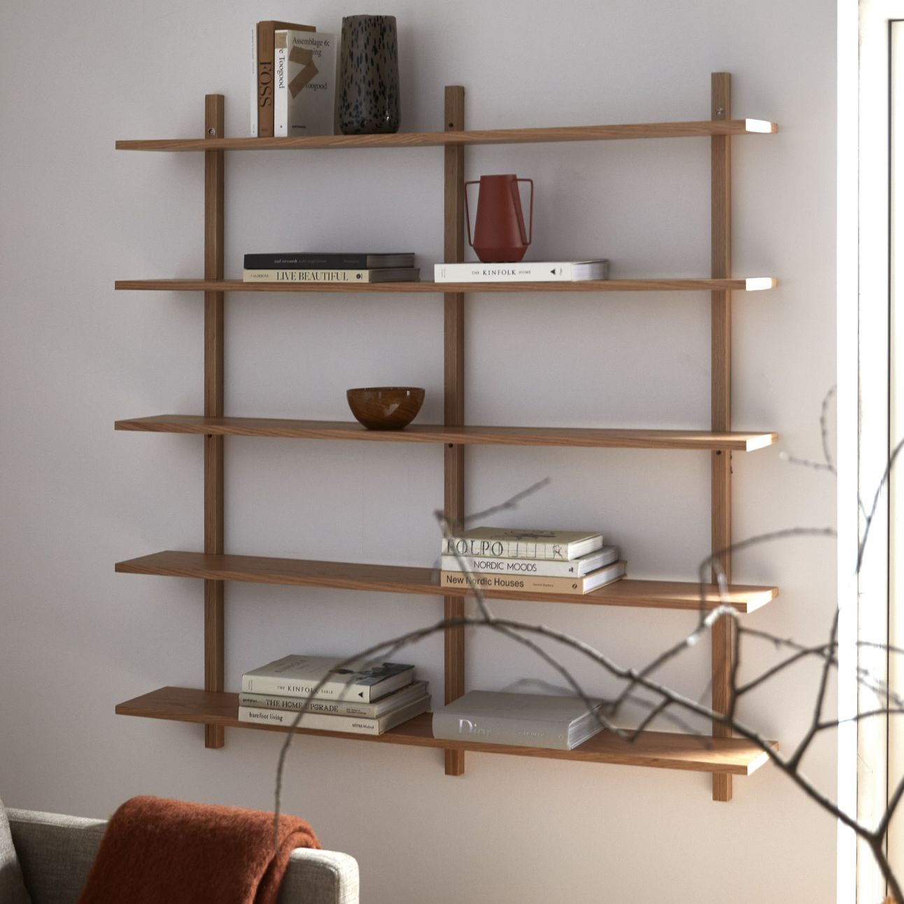 Vägghylla i trä på väggen med diverse prydnadssaker ovanpå