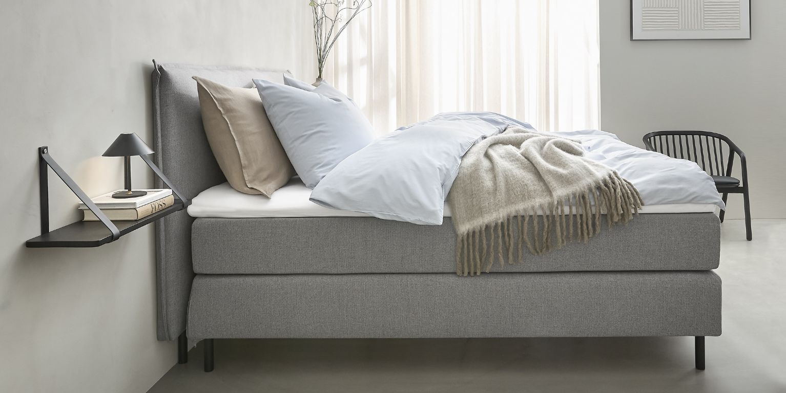 Boxmadrass i grått sedd från sidan