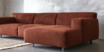 Design uden navn - 2024-12-27T222537.490.jpg Röd schäslongsoffa stående på betonggolv