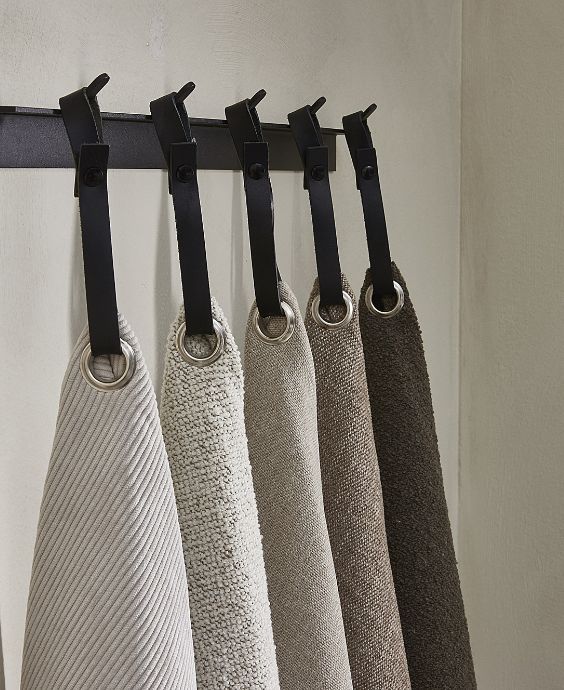 5 tygprover hängande på krokar