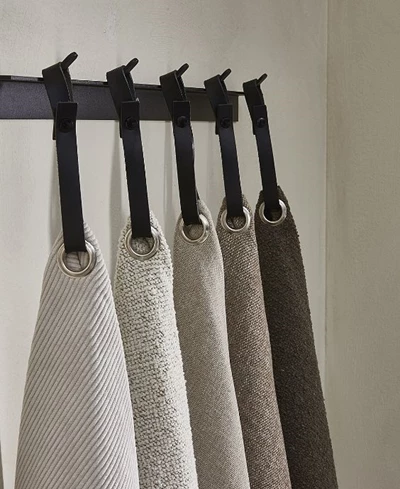 5 tygprover hängande på krokar