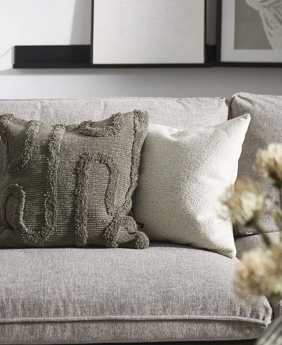 En grå och en vit kudde på grå soffa