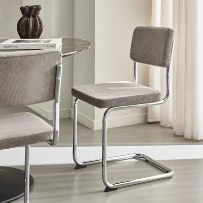 Frisvingerstol med stålram. Sätet och ryggen är stoppade i grått tyg