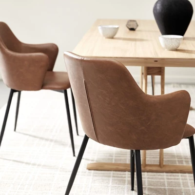 Spisebordsstole i brunt kunstlæder og med sorte stålben