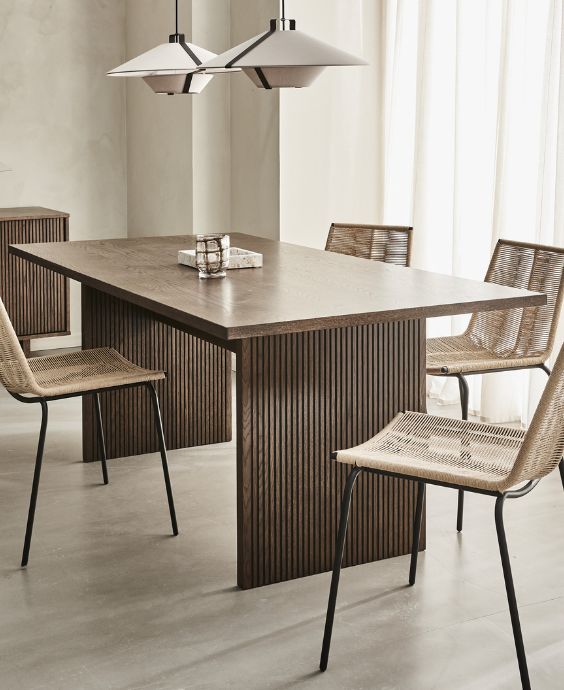 Matsplats i brunaktiga nyanser bestående av matbord, stolar, pendellampor samt lite prydnadssaker