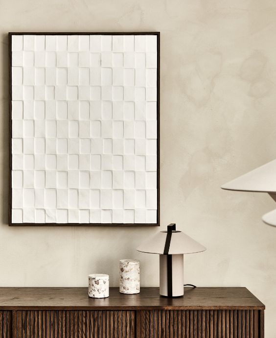 Vita dukbilder med struktur hängande över brun skänk