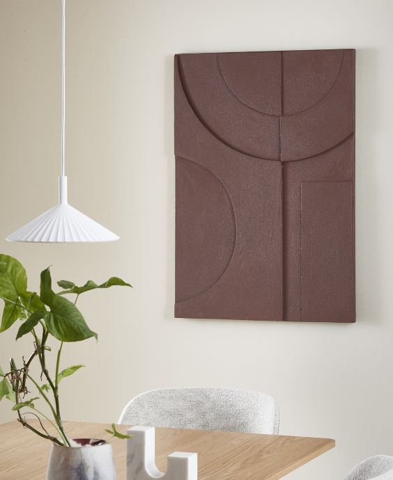 Rödbrunt dukbilde hängande på vägg