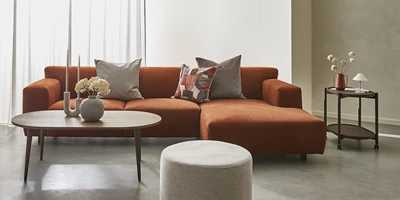 populaer-siena.jpg Vardagsrum med en chaiselongsoffa i orange i centrum