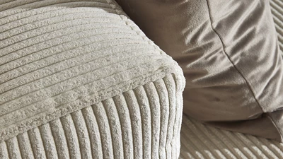 Närbild av soffa i vit med räfflad design