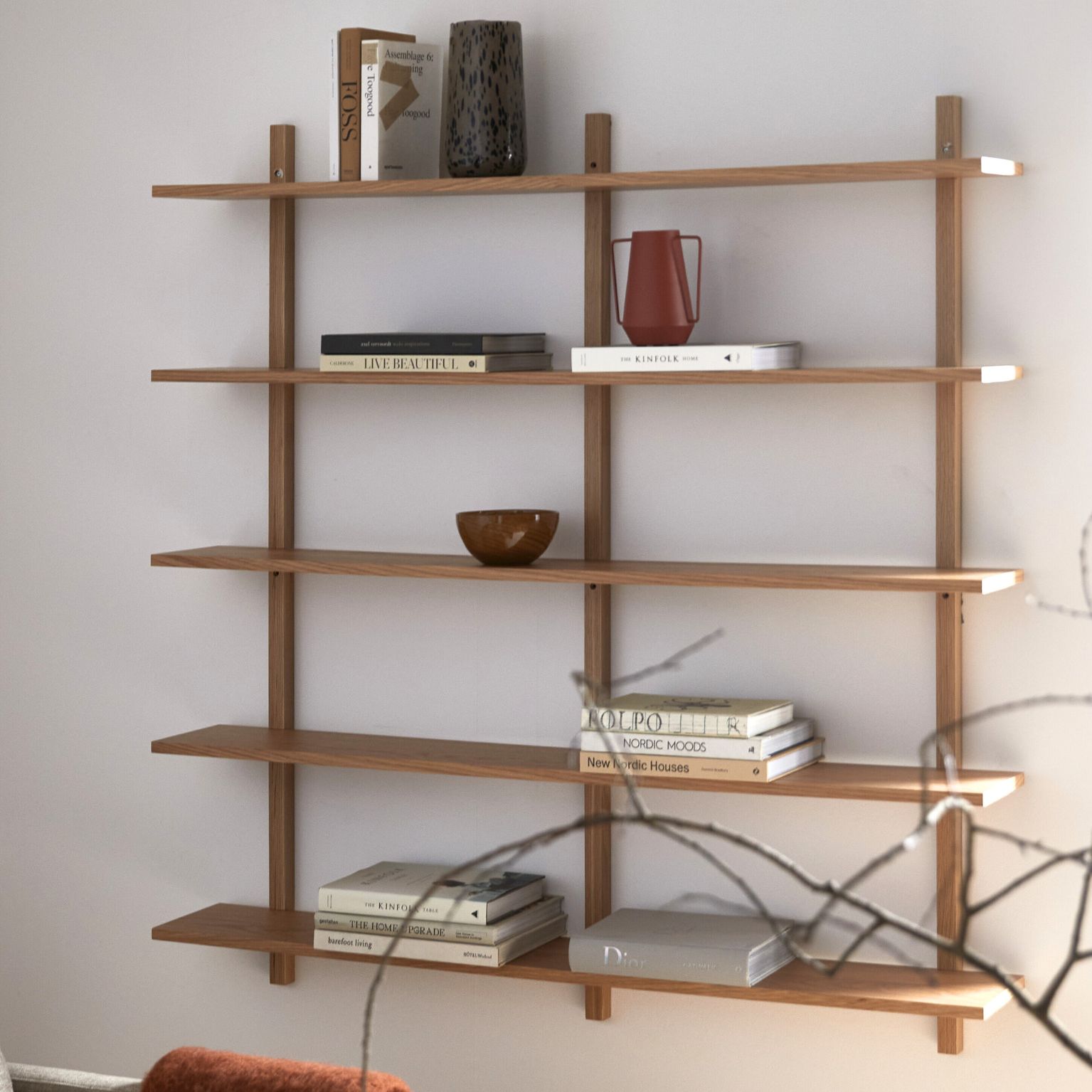 Vägghylla i trä med en massa olika saker på