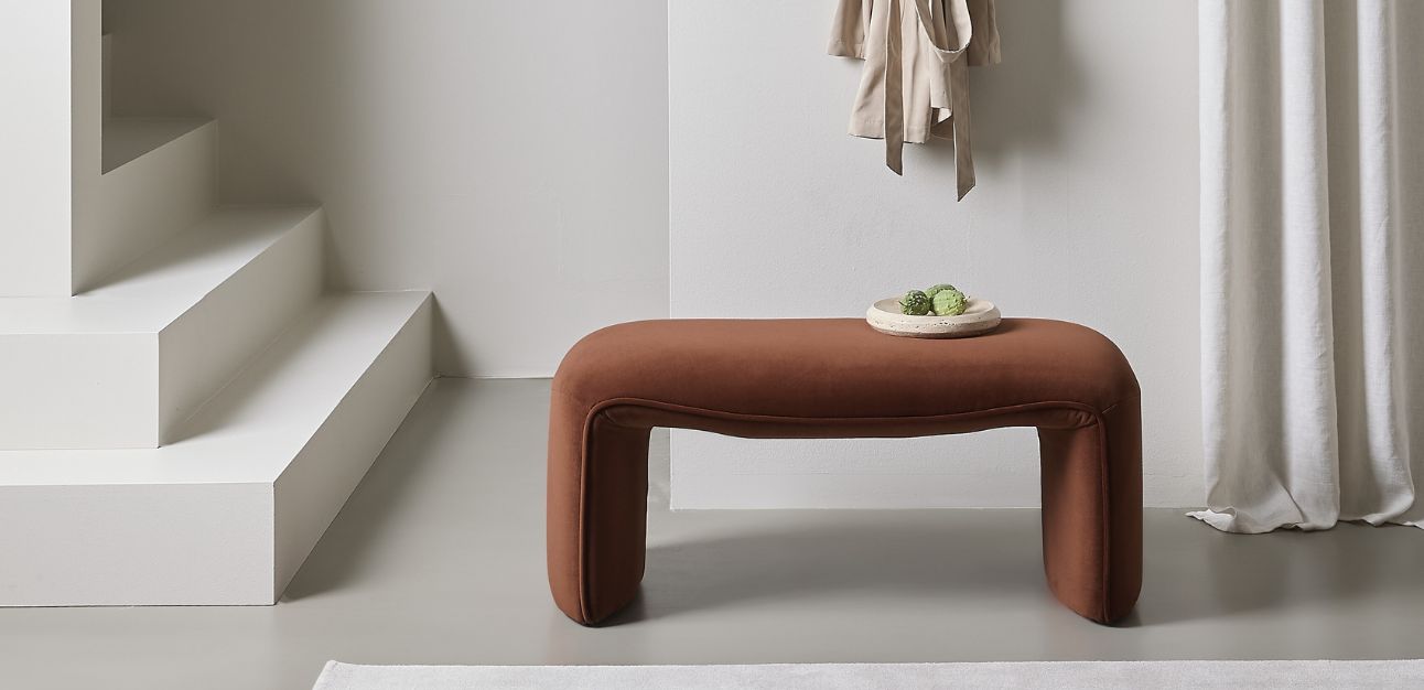 Modern brun läderbänk i ett minimalistiskt rum vid vita trappor