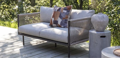 2 pers.jpg 2-sits loungesoffa med grå dynor stående på terrass