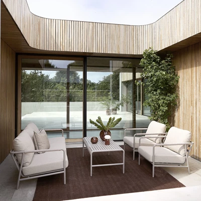 Tilbagetrukket terrassemiljø med loungesæt i lyse beige farver