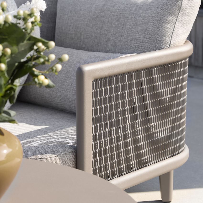 Närbild på grå utemöbel med metallnät och blomsterdekoration i förgrunden.