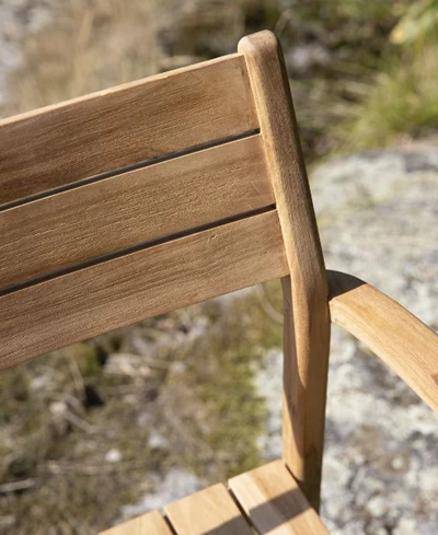 Närbild av trästolens ryggstöd med fokus på horisontella plankor.