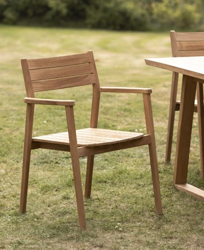 Två enkla teakstolar och ett matchande bord utomhus.