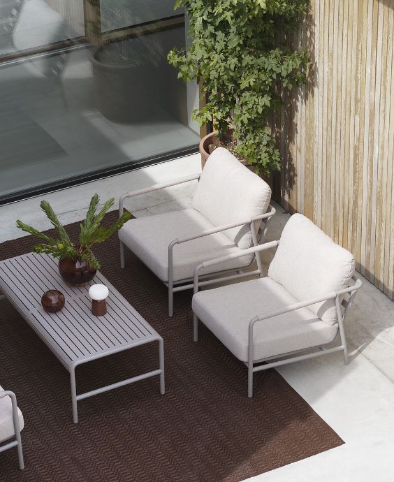 Modern terrass med en hörnplacerad soffgrupp och ett lågt bord.