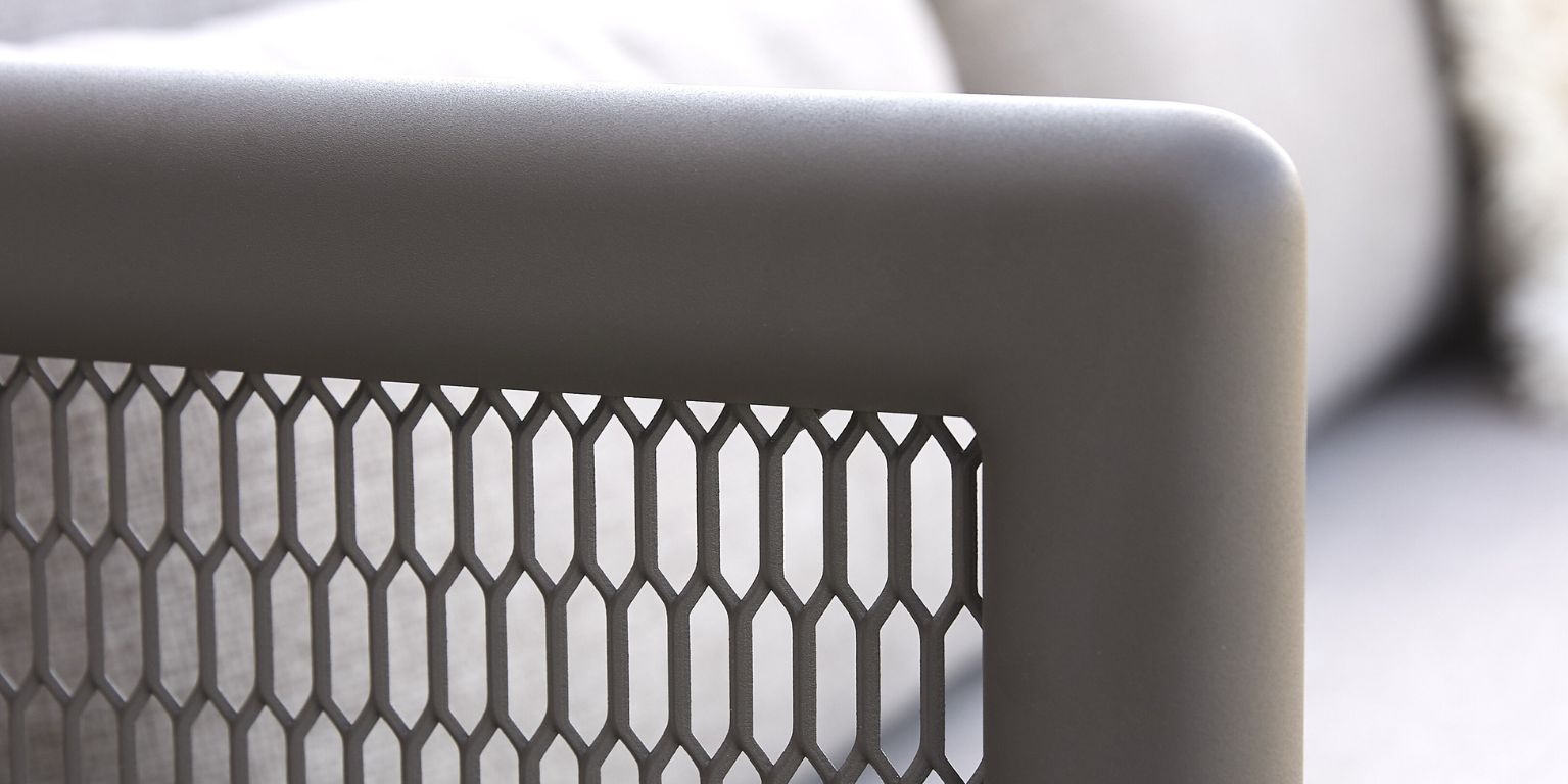 Närbild av grått metalliskt mönster på sidan av en utomhuslounge stol.