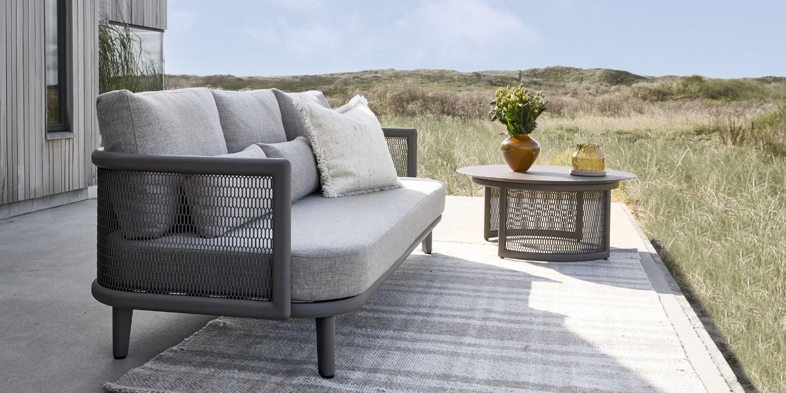 Soffa och soffbord på terrass i modern stil med utsikt över dynerna