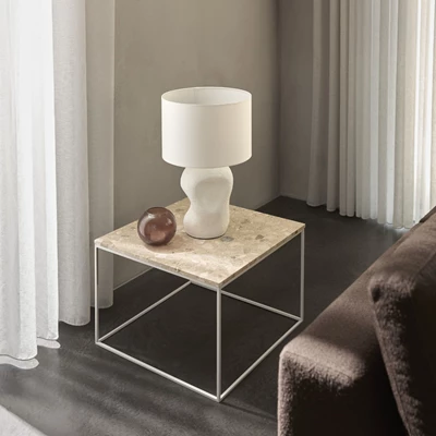 Modernt sidobord i marmorlook med en minimalistisk vit lampa och en dekorativ vas.