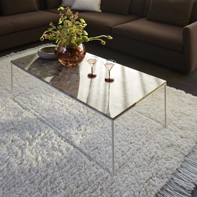 Soffbord i enkel design med drinkglas, vas och fat placerade ovanpå.