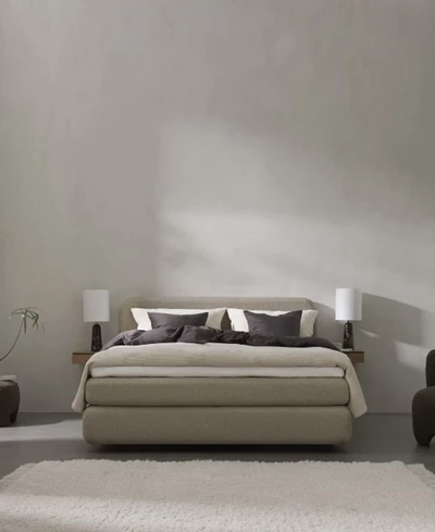 Kompakt boxsäng i ett litet sovrum med enkel inredning och beige väggfärg