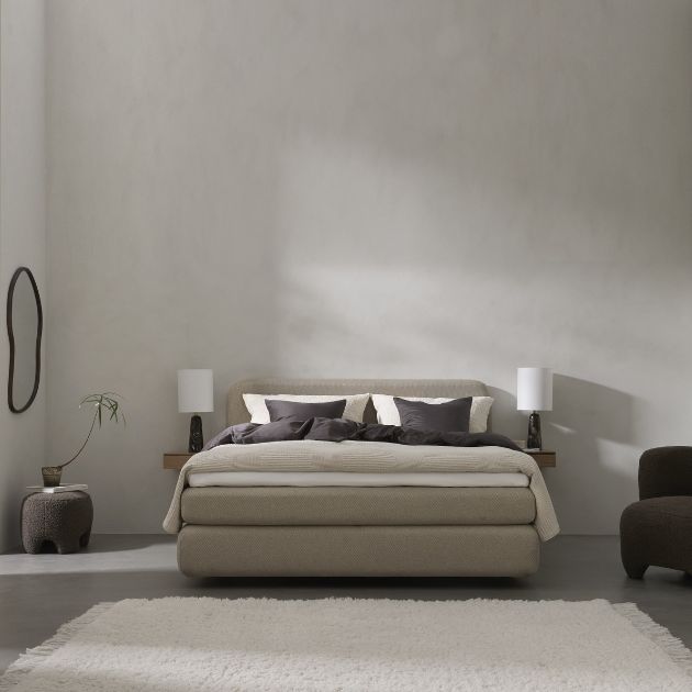 Elegant sovrum med en neutral färgpalett och lyxigt sängkläder, designat för komfort och stil