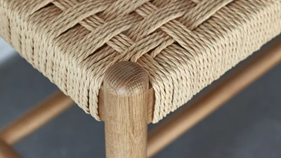 Närbild av en ek-bänk med sits i flätat papper
