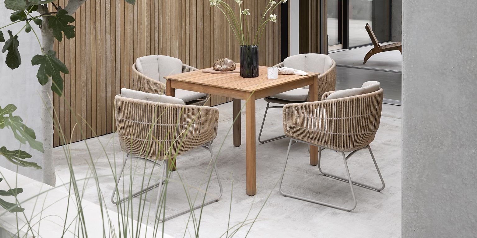 Utebord med fyra flätade stolar och dekoration