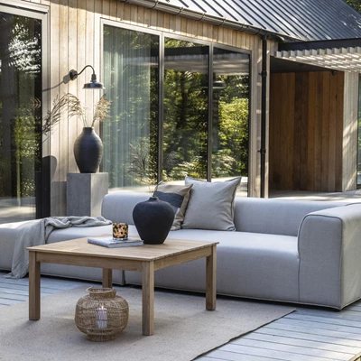 Modernt utomhus loungeområde med QuickDry Foam möbler, stilfullt arrangerade på en träterrass framför en byggnad klädd i glas