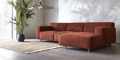 Design uden navn - 2025-03-20T123331.015.jpg Röd schäslongsoffa på betongolv