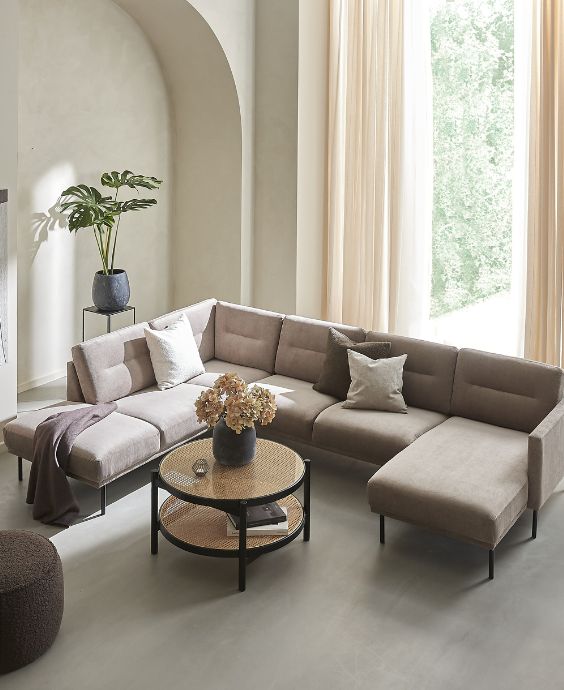 Stor sandfärgad u-soffa placerad i vardagsrummet