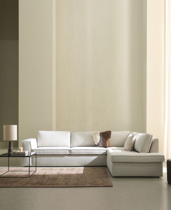 Vit hörnsoffa i ett minimalistiskt vardagsrum.