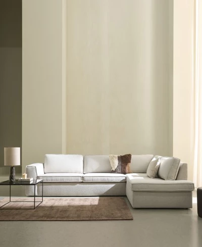 Vit hörnsoffa i ett minimalistiskt vardagsrum.