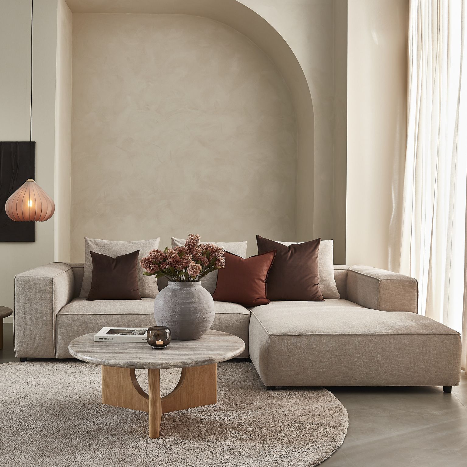 Beigefärgad flyttbar soffa i ett vardagsrum i liknande nyanser.