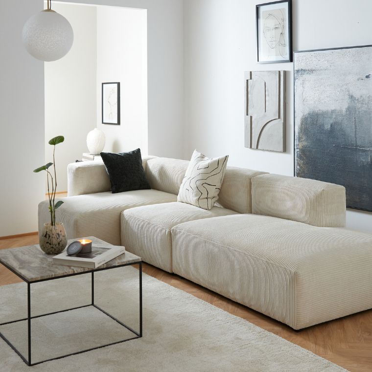 Vit modulsoffa i ett ljust vardagsrum.