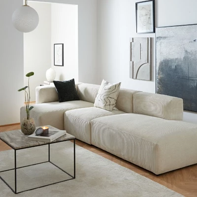 Aimee.jpg Vit modulsoffa i ett ljust vardagsrum.