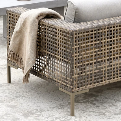 Närbild av en lounge-soffa i naturfärgad polyrattan