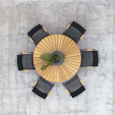 Runt trädgårdsbord med svarta stolar sett uppifrån