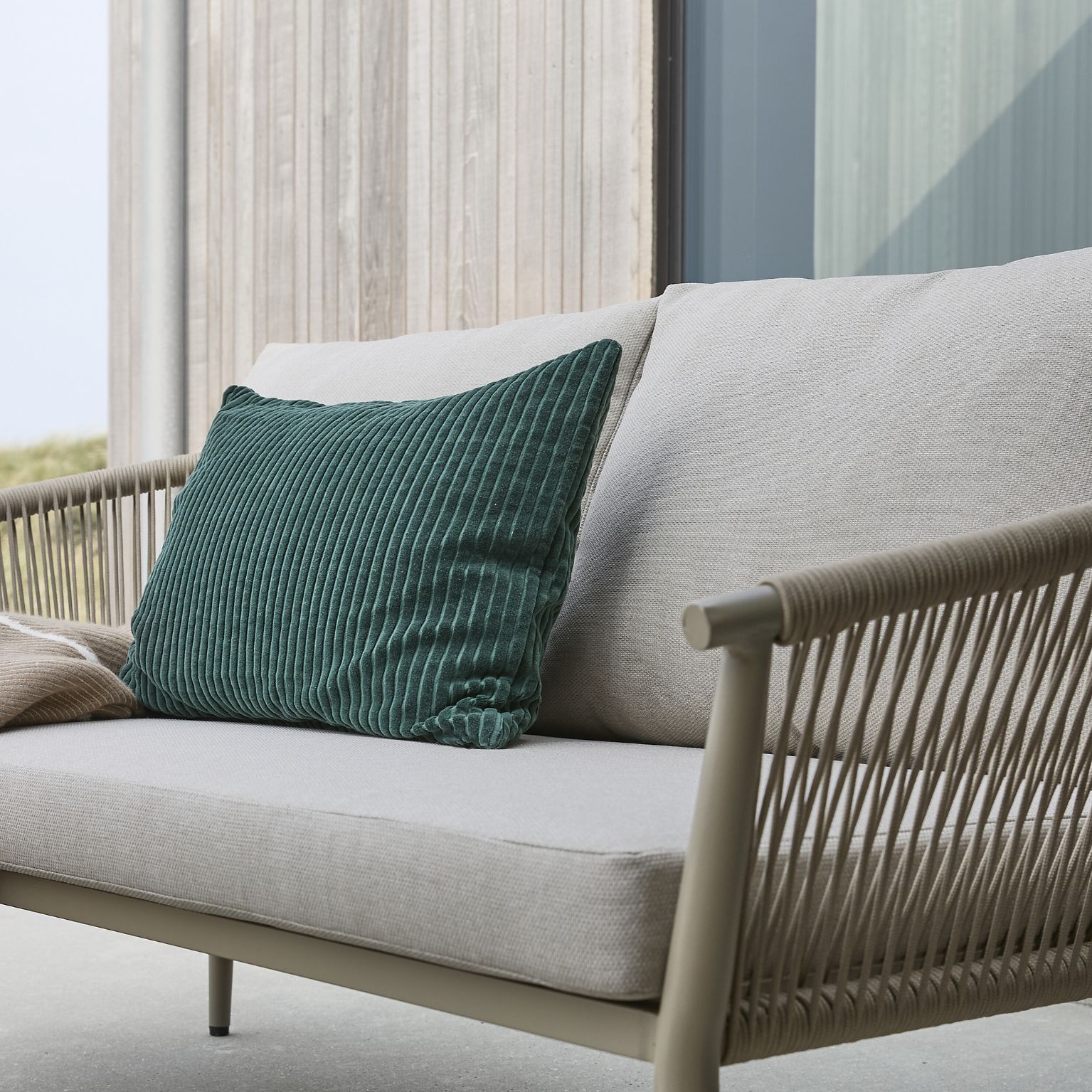 Loungesoffa med armstöd i flätning