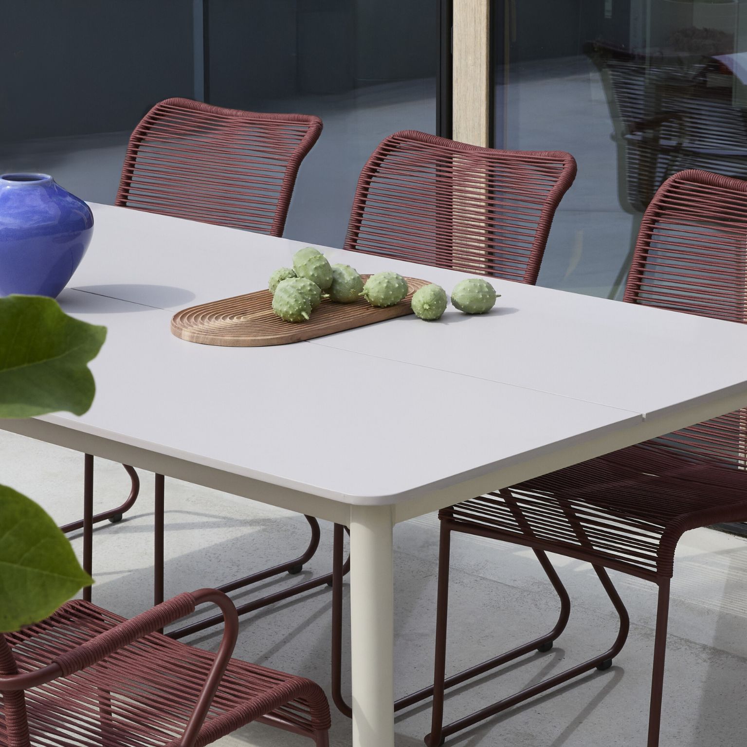 Trädgårdsbord i grått med röda trädgårdsstolar